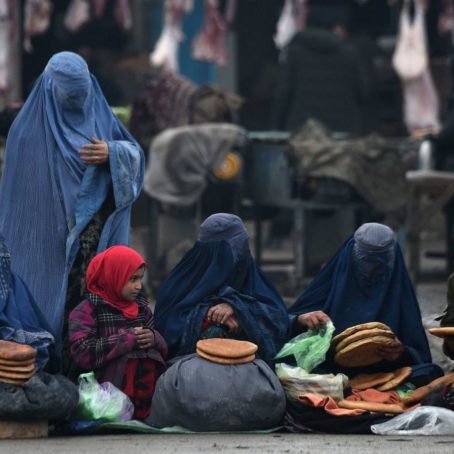 A group of women outside selling bread on the street
