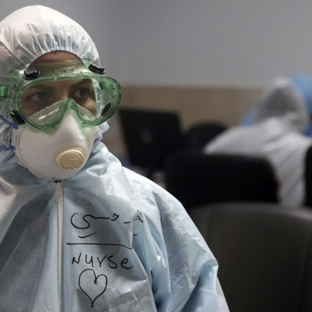 A nurse wearing full protective gear in a hospital