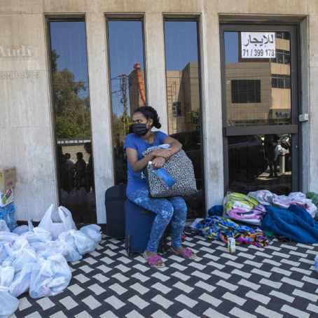 An Ethiopian domestic worker sits among personal belongings, waiting in front of the Ethiopian Consulate outside Beirut, where she and others were abandoned by their Lebanese employers last month.