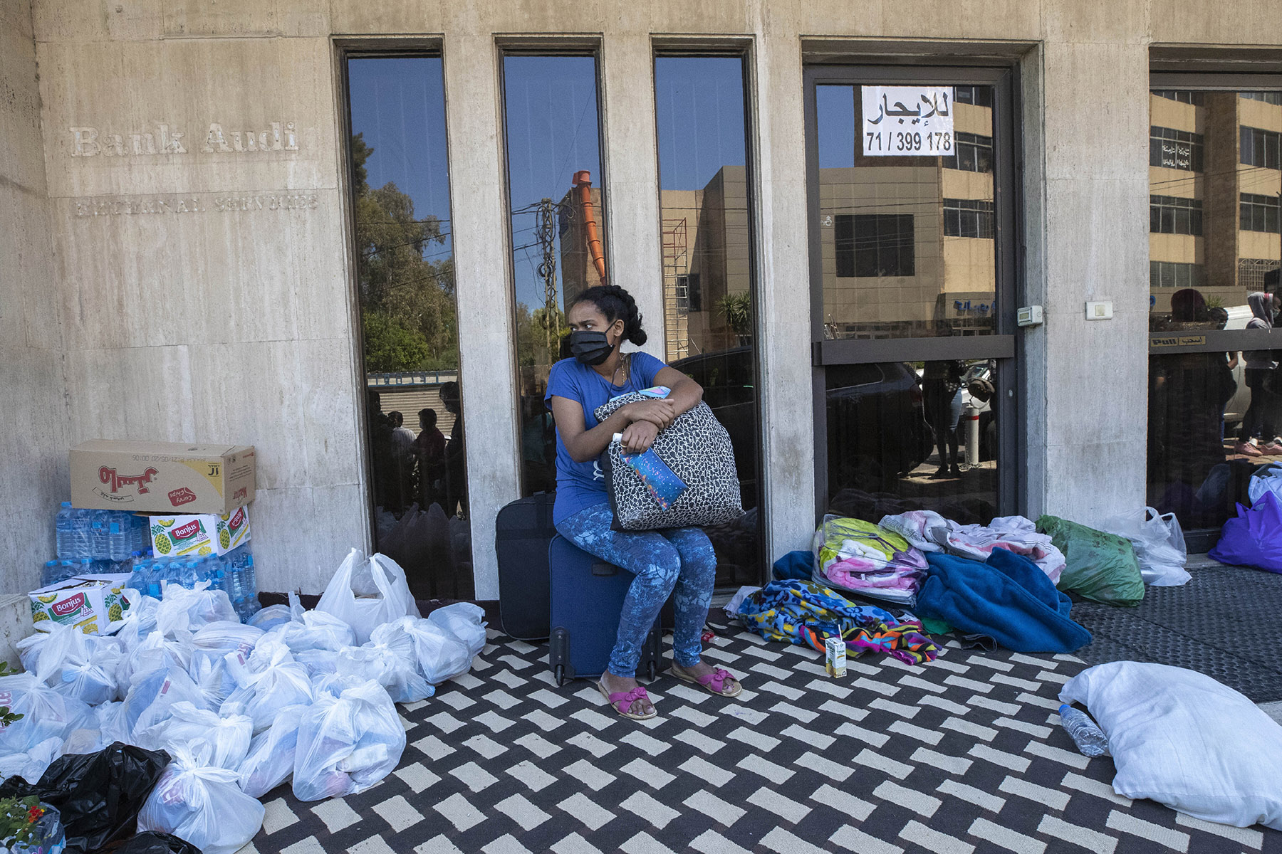 An Ethiopian domestic worker sits among personal belongings, waiting in front of the Ethiopian Consulate outside Beirut, where she and others were abandoned by their Lebanese employers last month.