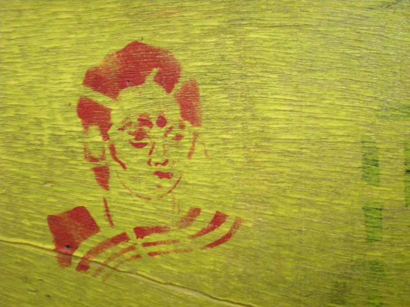 A drawing of a woman in red on a yellow wall