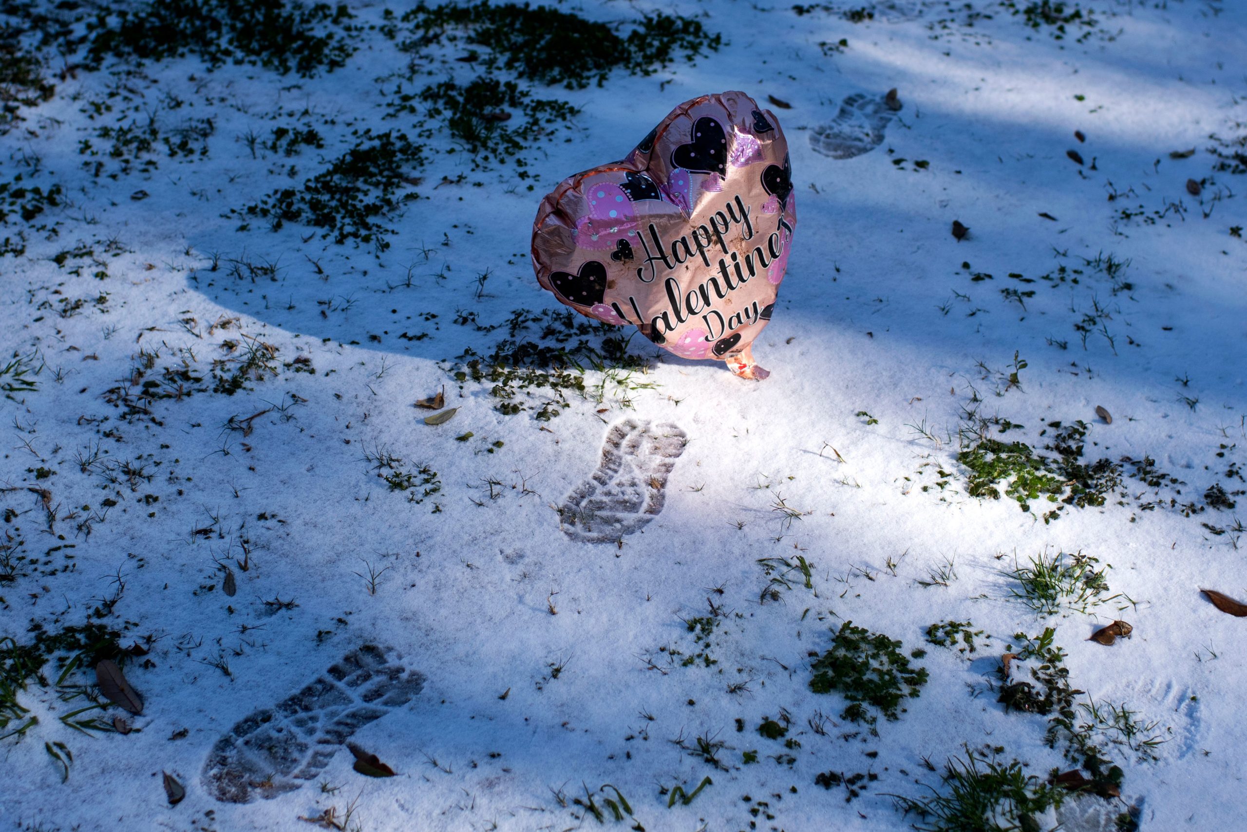 A photo of a heart-shaped Valentine's Day balloon in the snow