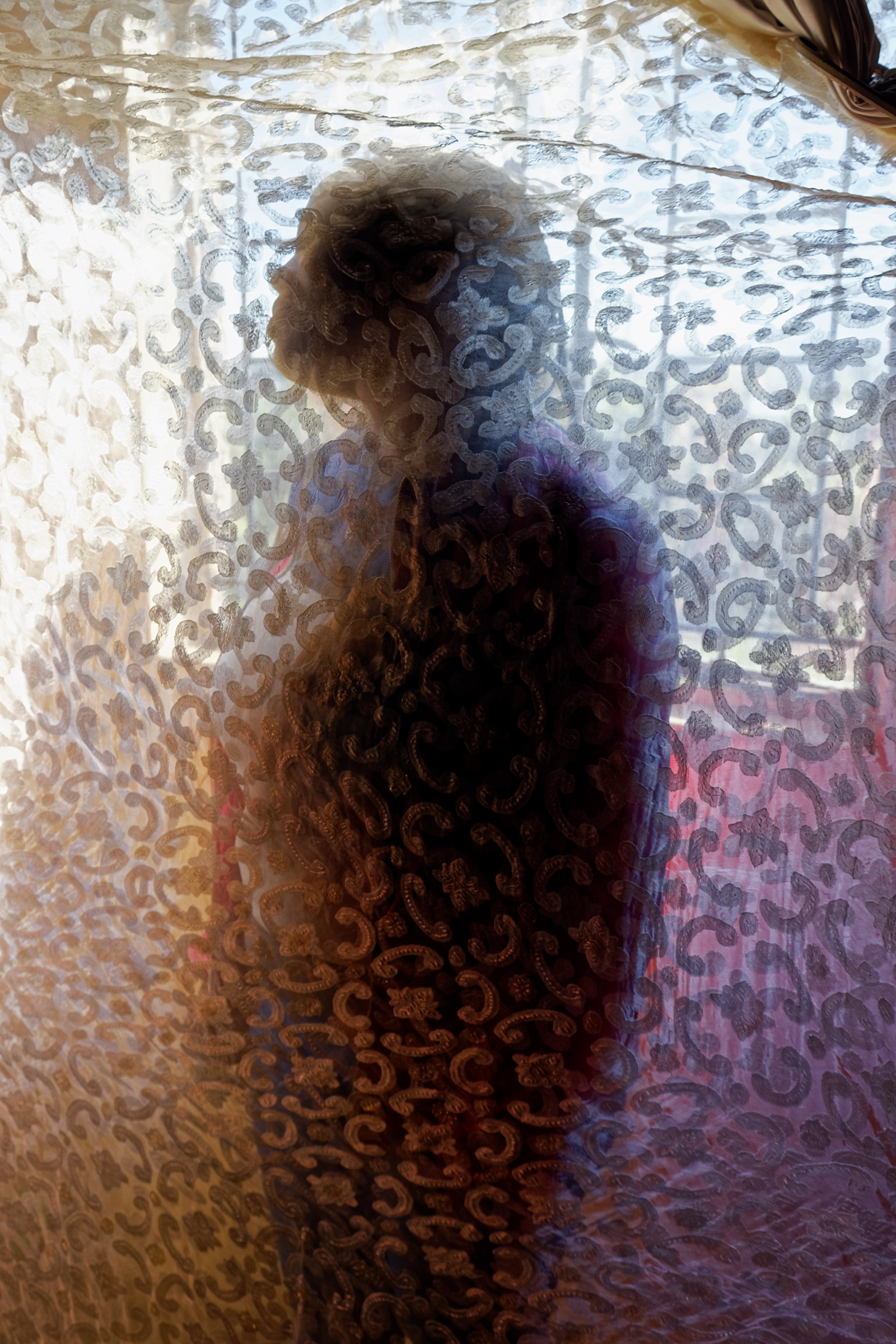 The silhouette of a person cast against semi-sheer fabric