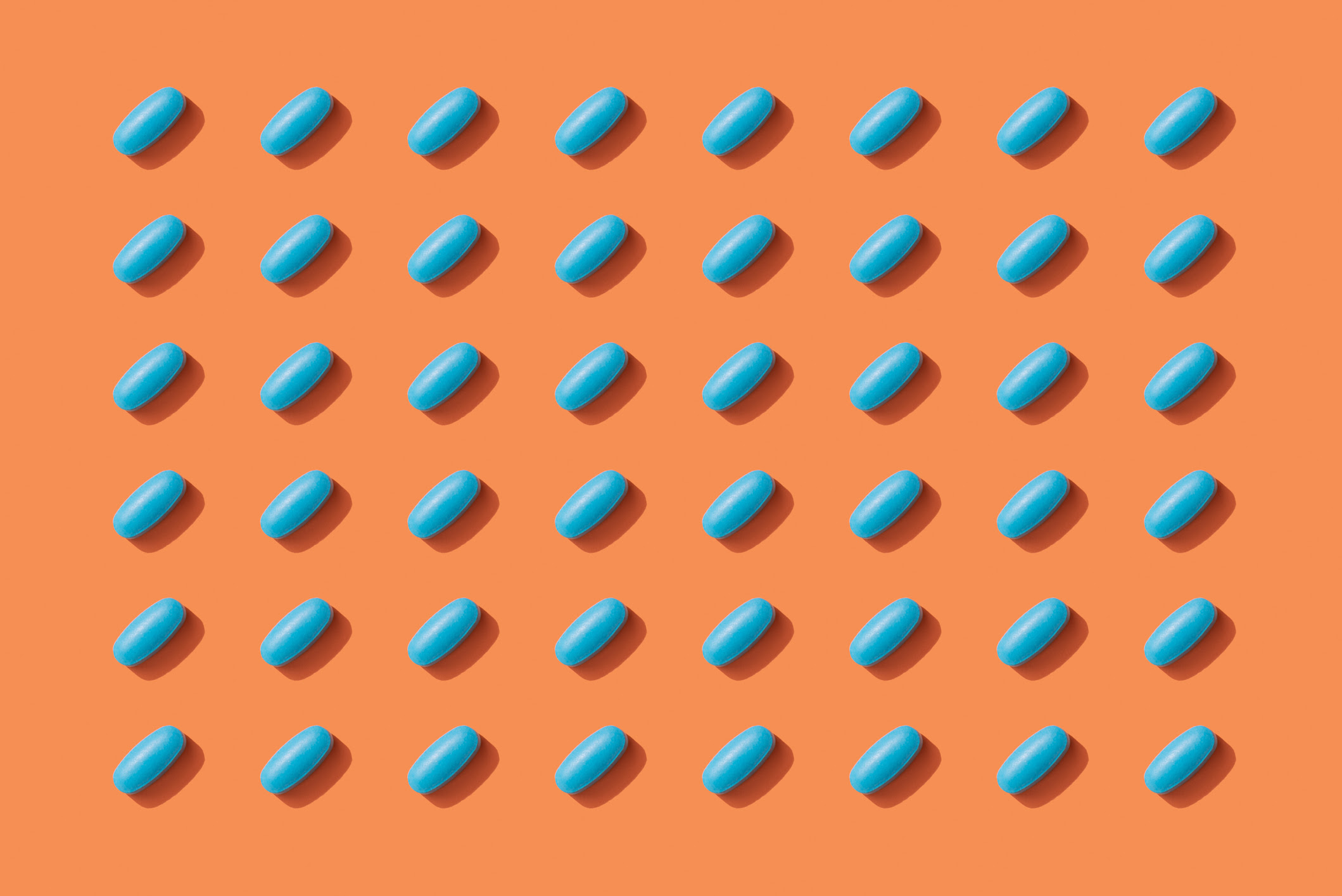 a series of blue pills on an orange background