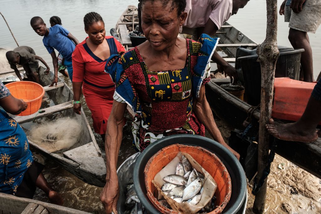 A photo of a woman holding a basket of fish