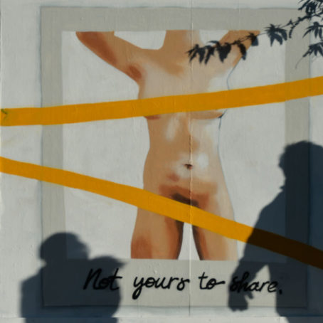 A photo of a mural depicting a naked woman's body with yellow stripes covering her chest and pelvis