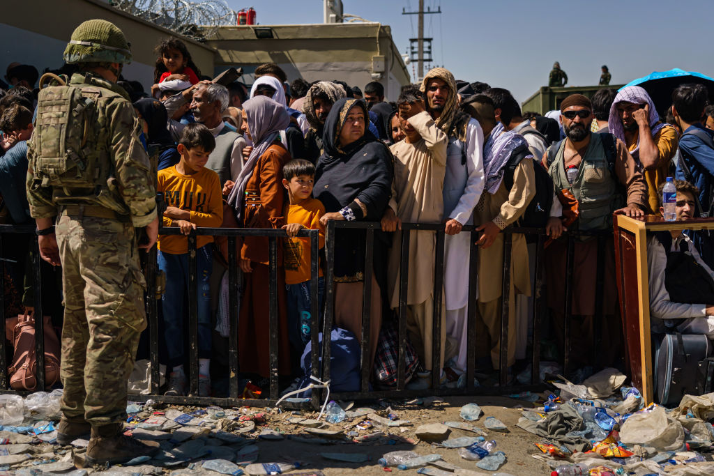 Photo of a packed crowd behind a temporary fence with liter on the ground