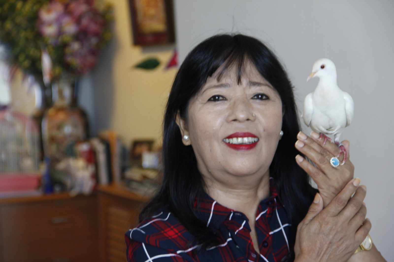 A photo of a woman posing with a bird in her hands