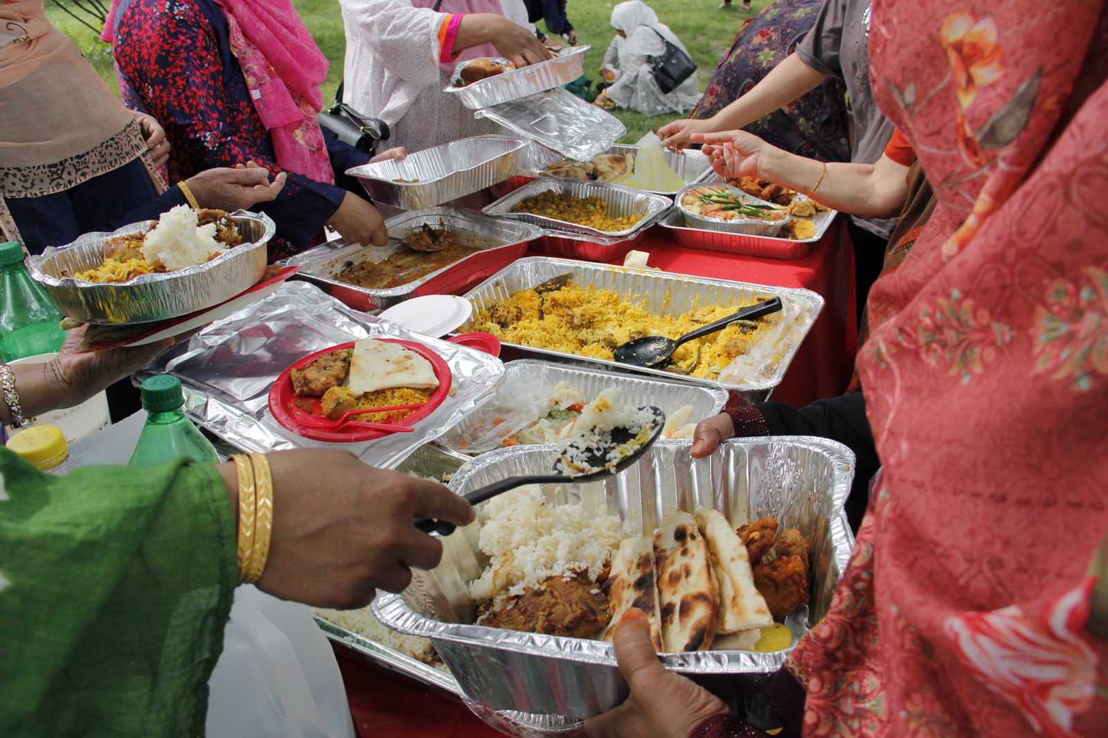 A photo of women serving themselves food at an outdoor gathering