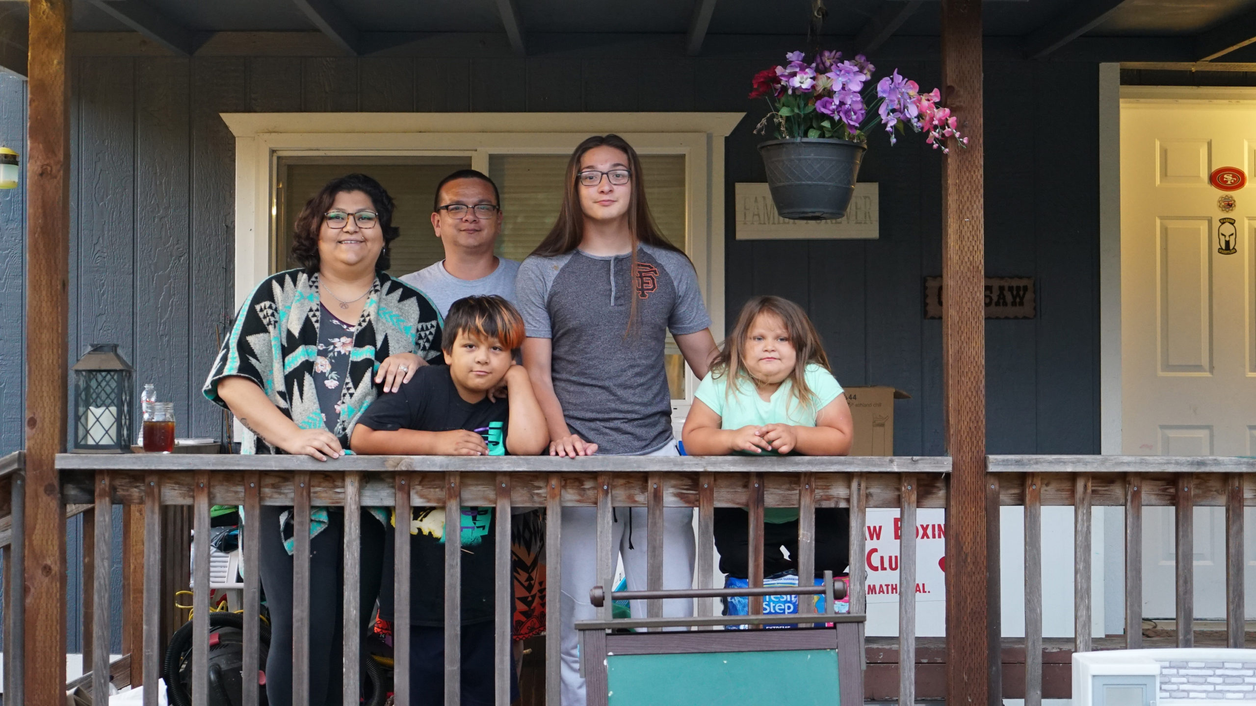 A photo of a family posing for a photo on a porch