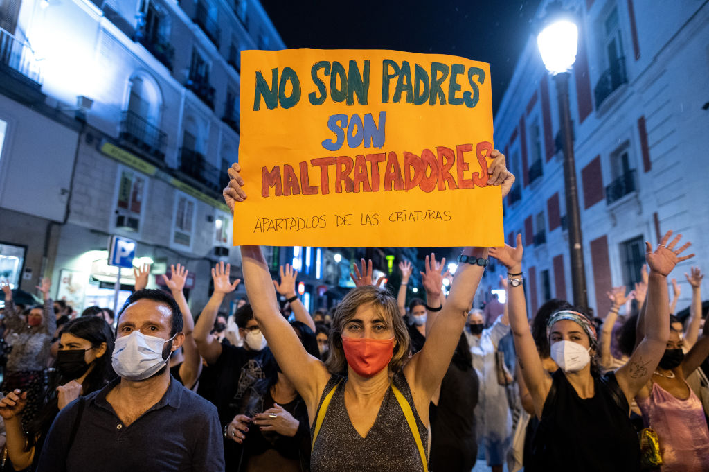 A woman protesting with a poster in Spanish