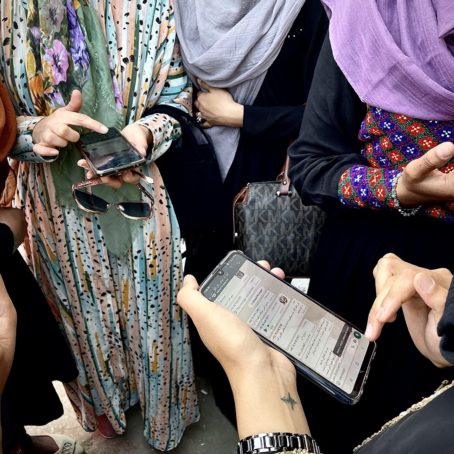 A photo of a group of women looking at cell phones