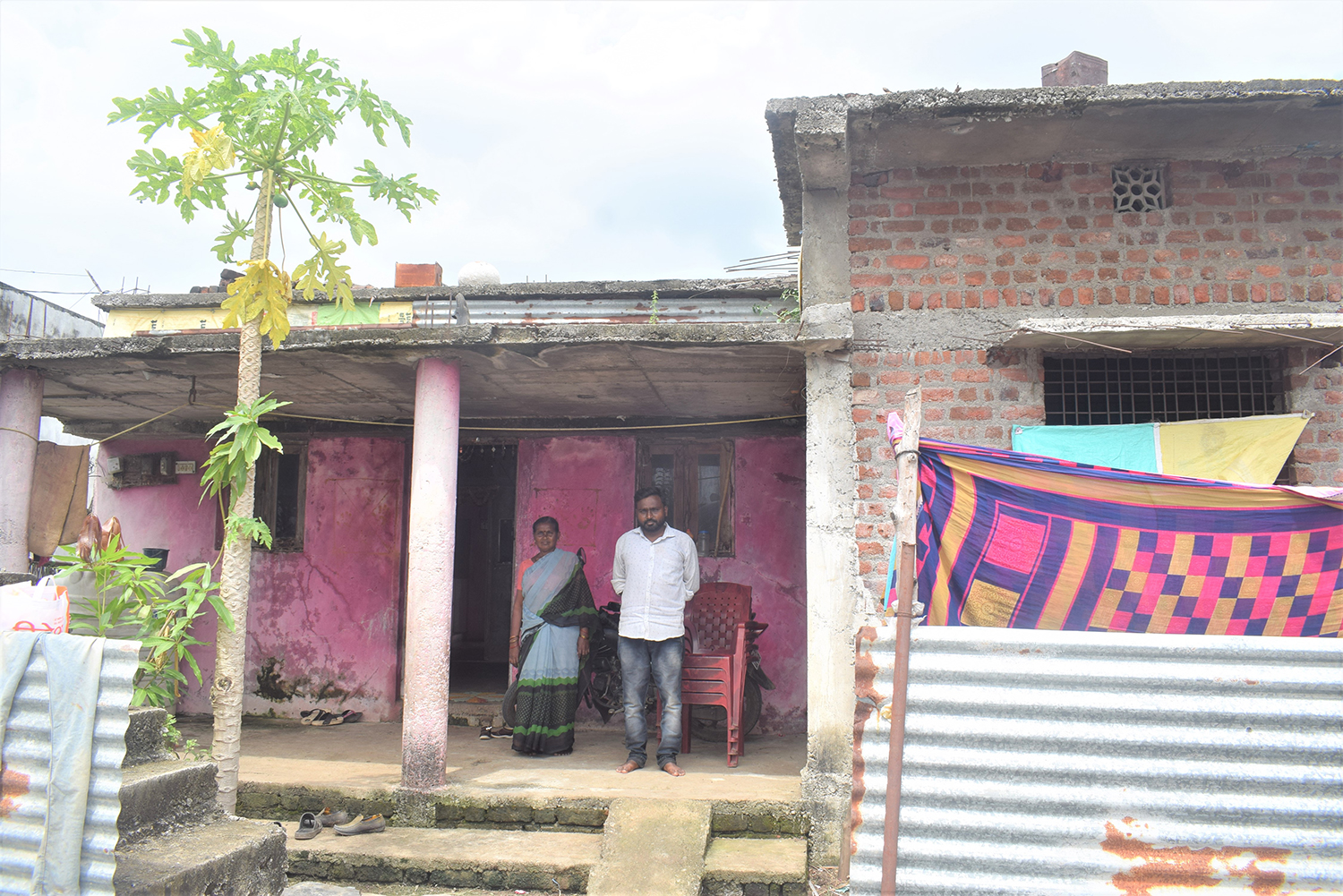 A photo of a man and a woman standing outside of a home