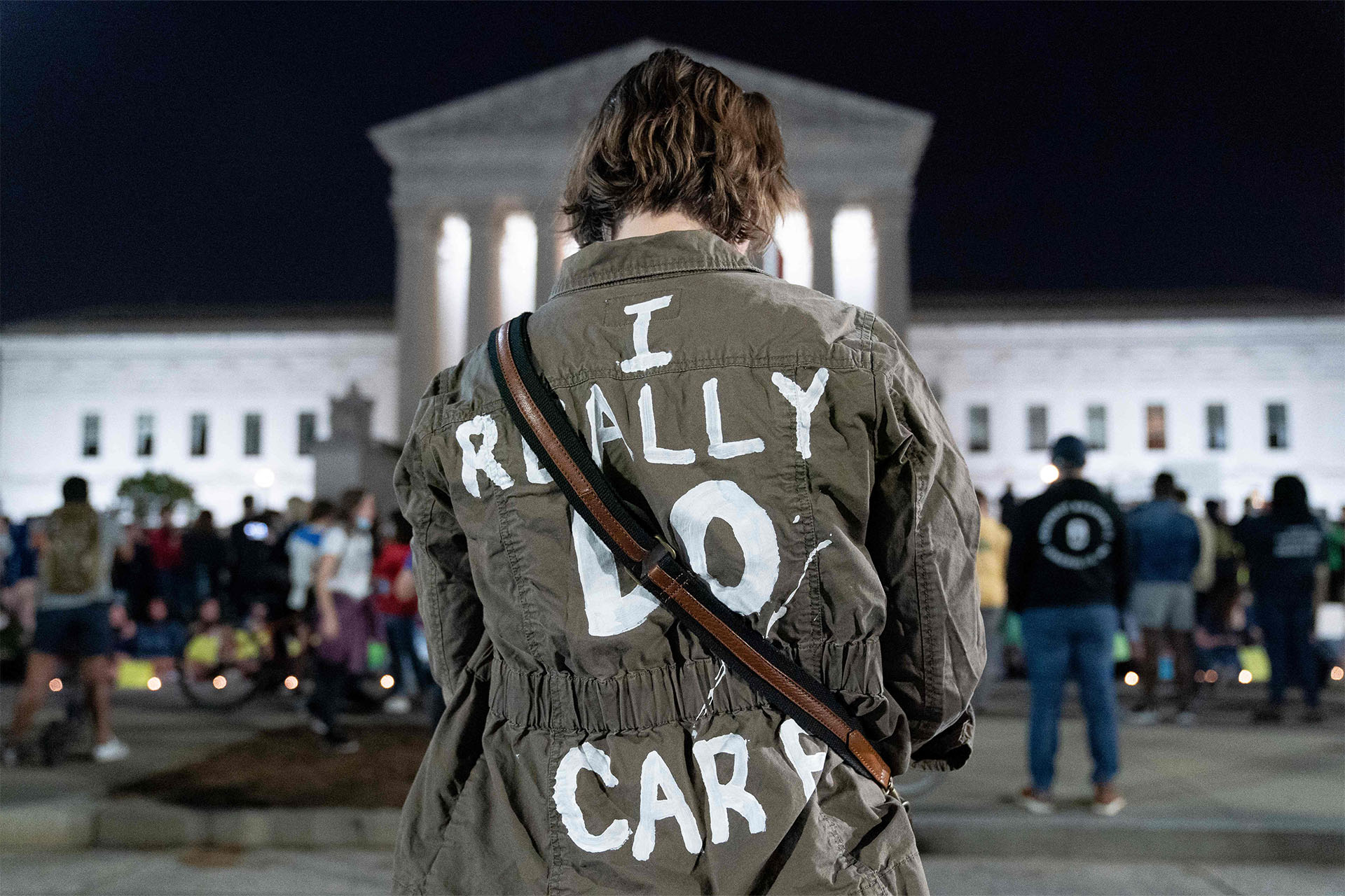 A photo of a woman wearing a jacket that says "I do really care"
