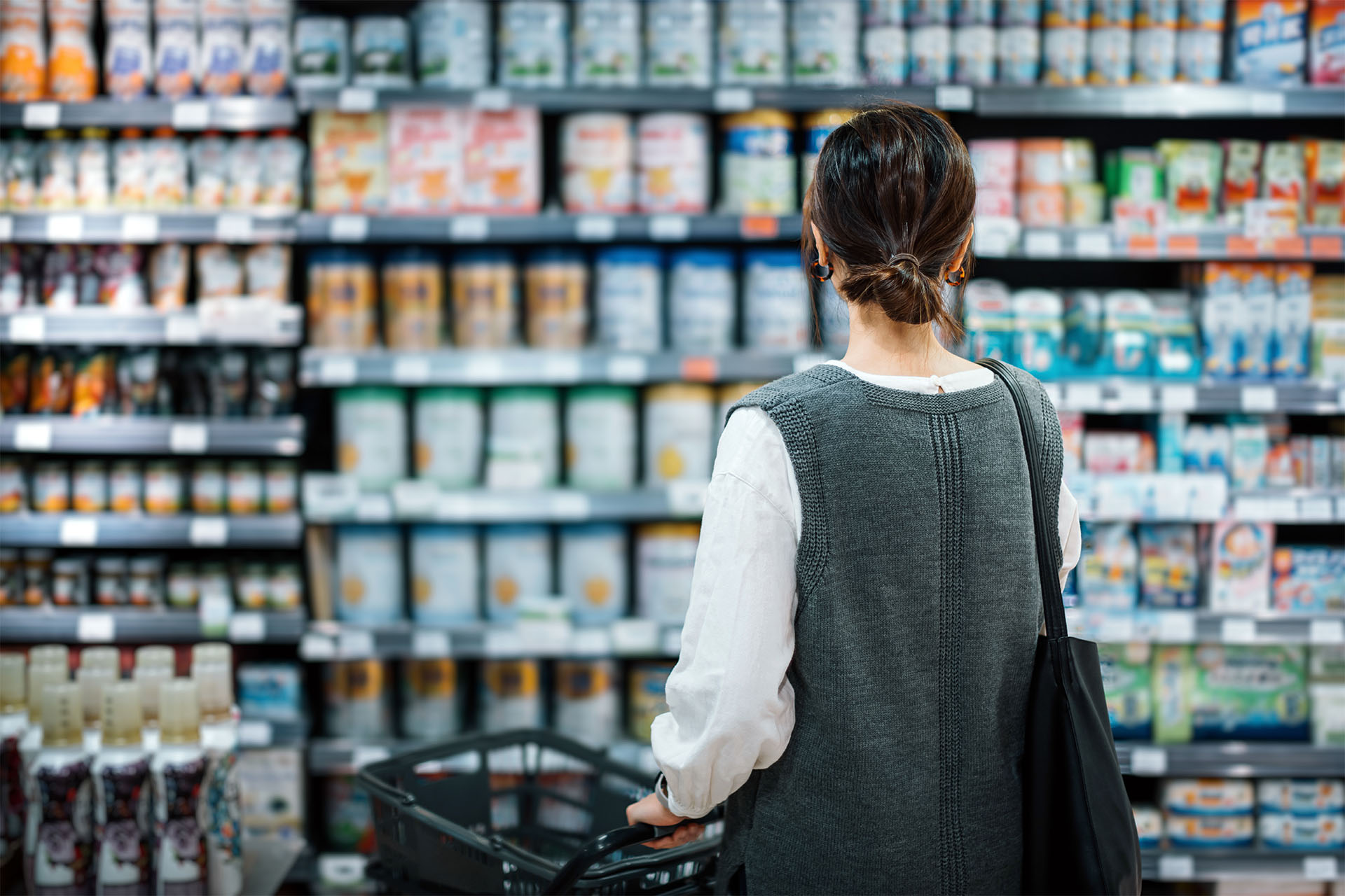 Photo of a person looking at items on a grocery store shelf