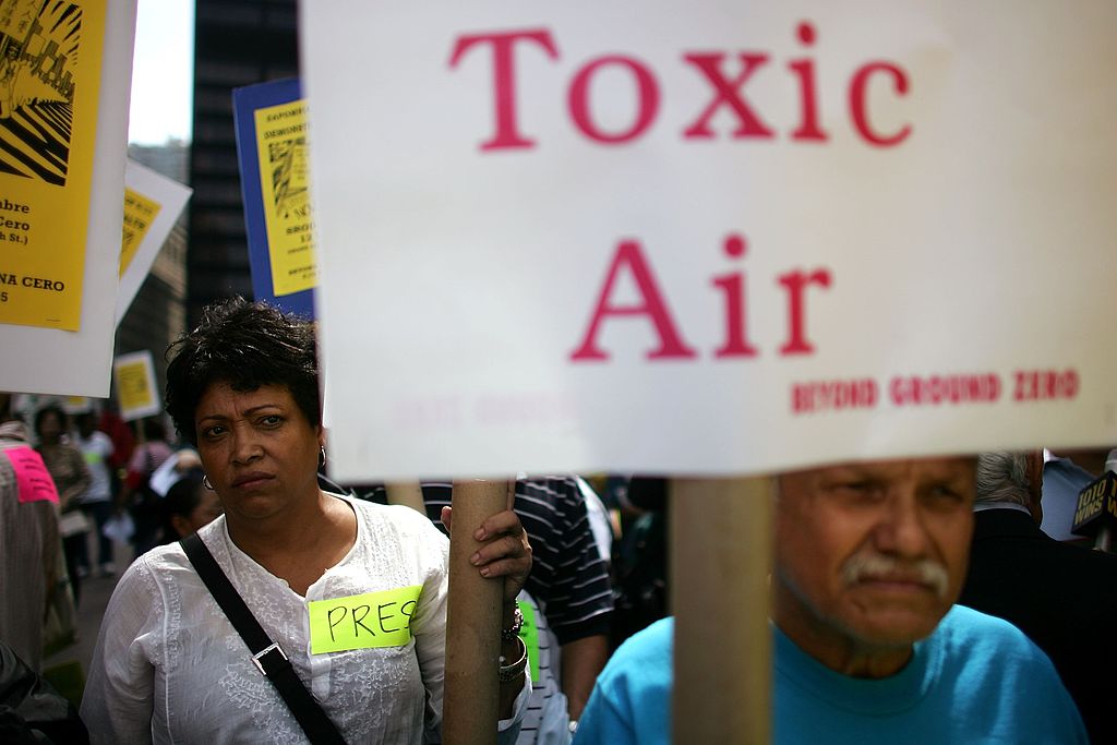 People protest in New York with a sign that says toxic air.