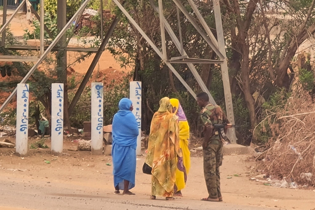 three women standing and talking to a soldier