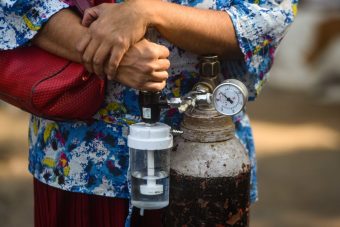 Delhi Hospitals Under Stress Amid Rising Covid Cases NEW DELHI, INDIA - APRIL 22: A woman holds onto her personal oxygen cylinder at LNJP Hospital, on April 22, 2021 in New Delhi, India. Delhi logged 26,219 fresh Covid-19 cases and 306 deaths due to the Covid on Thursday amid a growing clamour for oxygen and hospital beds in the city. The national capital's cumulative tally rose to 9,56,348 and the death toll stood at 13,193, according to health bulletin. (Photo by Amal KS/Hindustan Times via Getty Images)